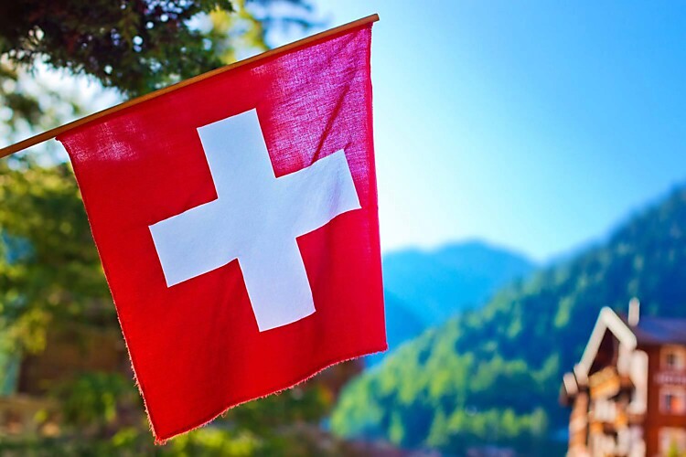 Schweizer Flagge vor einer Berglandschaft